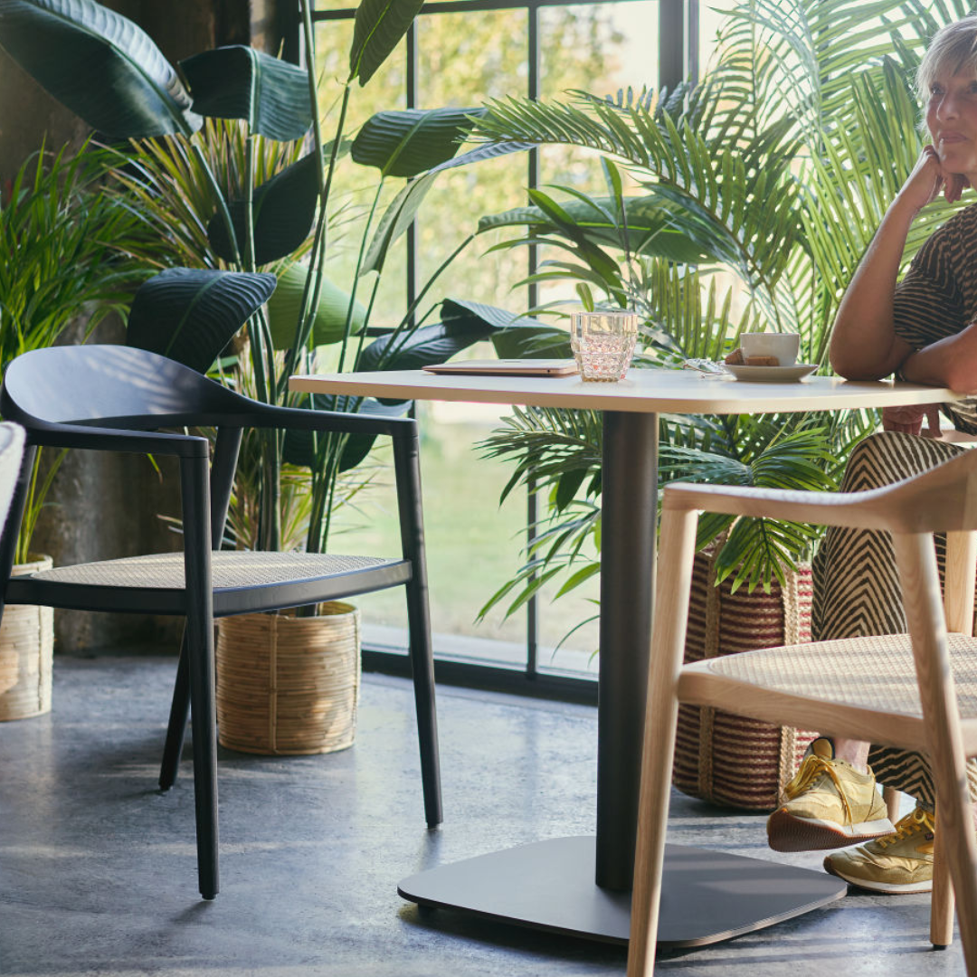 A woman is sitting in the biophilic office area