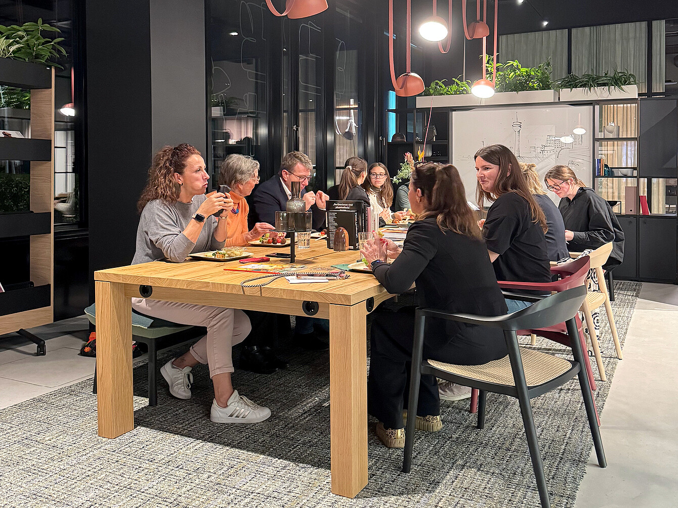 Los visitantes de HUB West comen juntos en la mesa del equipo