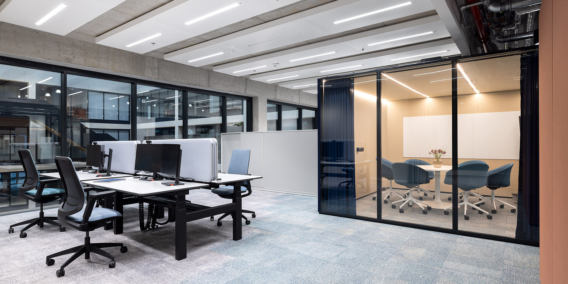 Modern team workstations at Veolia with height-adjustable “temptation smart twin” double workstations and ergonomic se:flex swivel chairs in a bright, open-plan office. 
