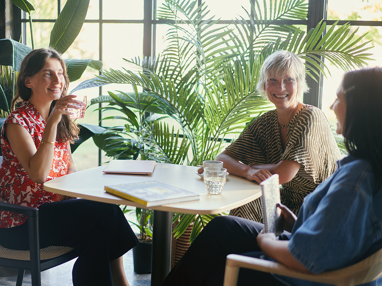 Tre donne conversano animatamente in ufficio