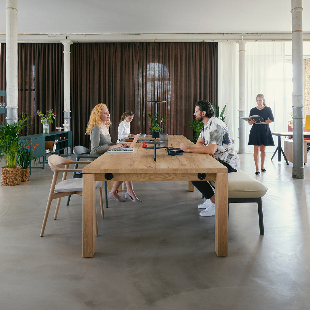 people sitting at a long wooden table